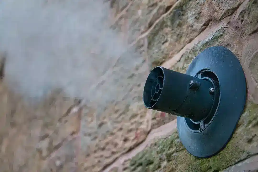 Steam from a condensing boiler flue on a brick wall