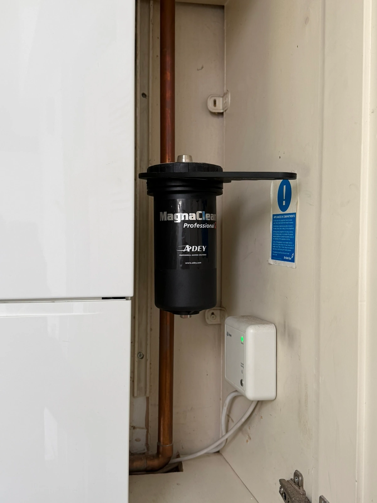 MagnaClean magnetic filter installed beside a boiler in a cupboard